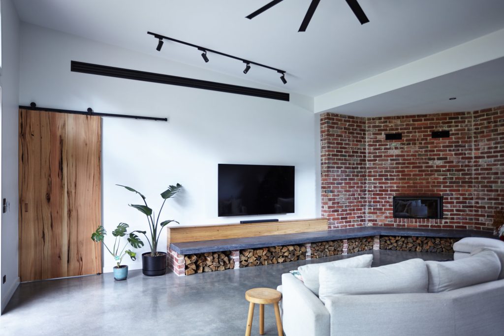 Modern living room with brick wall and wood accents.